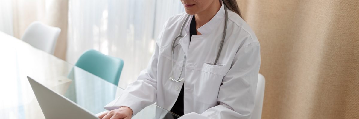 Medical Specialist Working On Laptop At Office - AD3 Contabilidade